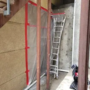 Plastic containment and exterior access during Mount Washington water damage wall repair